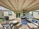 Covered outdoor patio with stylish seating, grill, and ceiling fan at 4190 Bull St, St Cloud, FL 34772