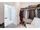 Walk-in closet with metal shelving, hanging clothes, and a chair at 4190 Bull St, St Cloud, FL 34772