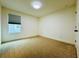 A simple bedroom with neutral paint and carpet has a window providing natural light at 5019 Down Ct, St Cloud, FL 34772