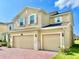 Two-story home with stone accents, a brick driveway, and a three-car garage at 5019 Down Ct, St Cloud, FL 34772