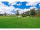 Scenic backyard view with lush green lawn and a tranquil pond, offering a peaceful outdoor space at 5414 Log Grove Ln, Orlando, FL 32829