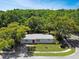 Aerial view of a single-story home with a well-manicured lawn and tree-lined street in a residential area at 5464 Windridge Ln, Orlando, FL 32810