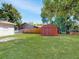 Expansive backyard features a storage shed, wooden fence, and lush green lawn, perfect for outdoor activities at 5464 Windridge Ln, Orlando, FL 32810
