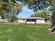 Large, verdant backyard with a screened-in porch and mature trees, offering a serene outdoor space at 5464 Windridge Ln, Orlando, FL 32810