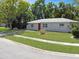 Charming single-story home with a well-maintained lawn, featuring a red front door and bright exterior at 5464 Windridge Ln, Orlando, FL 32810