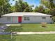 Charming one-story home with well-maintained lawn and a bright red front door at 5464 Windridge Ln, Orlando, FL 32810