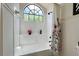 Bright bathroom with a shower-tub combo, flowers, and decorative window at 554 Northbridge Dr, Altamonte Springs, FL 32714