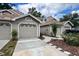 Exterior view of townhomes with attached garages and landscaping under a blue sky at 554 Northbridge Dr, Altamonte Springs, FL 32714