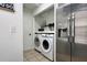 Laundry area featuring a washer, dryer, stainless steel refrigerator, and storage shelves at 554 Northbridge Dr, Altamonte Springs, FL 32714