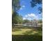 Beautiful lake view surrounded by green spaces, benches, and mature trees within the community at 6040 Peregrine Ave # A01, Orlando, FL 32819