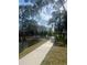 A sidewalk winding through a community with a lake and fountain view, bordered by trees at 6040 Peregrine Ave # A01, Orlando, FL 32819