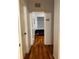 Hallway with hardwood flooring leading to a bedroom with a window and a purple couch at 6141 Metrowest Blvd # 303, Orlando, FL 32835
