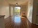 Bright living room with wood floors, ceiling fan, and sliding glass door to the balcony at 6141 Metrowest Blvd # 303, Orlando, FL 32835