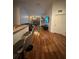 Open-concept living room with hardwood floors, ceiling fan, and bar seating at 6141 Metrowest Blvd # 303, Orlando, FL 32835