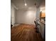 Open-concept living room with hardwood floors and barstool seating at the kitchen counter at 6141 Metrowest Blvd # 303, Orlando, FL 32835
