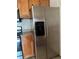 Close-up of a stainless steel refrigerator with an ice and water dispenser, next to wood cabinets at 6141 Metrowest Blvd # 303, Orlando, FL 32835