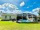 A nice backyard featuring a pool, screened lanai, lush lawn, and outdoor grill at 618 N Hampton Dr, Davenport, FL 33897