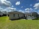 Spacious backyard featuring an in-ground pool in screened lanai, lush lawn, and an outdoor grill at 618 N Hampton Dr, Davenport, FL 33897