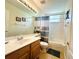 Well-lit bathroom with a large mirror, neutral tile, and a shower-tub combination at 618 N Hampton Dr, Davenport, FL 33897