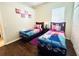 Bright bedroom featuring two twin beds with Frozen themed decor and dark wood flooring at 618 N Hampton Dr, Davenport, FL 33897