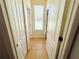 Hallway featuring two white doors, a window, and neutral tile flooring at 618 N Hampton Dr, Davenport, FL 33897
