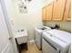 Functional laundry room with modern washer and dryer, utility sink, and cabinet storage at 618 N Hampton Dr, Davenport, FL 33897