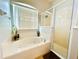 Bright bathroom featuring a soaking tub, a walk-in shower, tile floors, and updated fixtures at 618 N Hampton Dr, Davenport, FL 33897