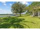 Lush backyard featuring mature trees, a patio area, and serene lake views with a private dock at 6200 Alligator Lake E Shr, St Cloud, FL 34771