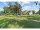 Sprawling backyard with lush grass, mature trees, and views of the lake and dock at 6200 Alligator Lake E Shr, St Cloud, FL 34771