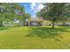 Expansive backyard boasts lush green lawn, mature trees, and covered patio with outdoor seating at 6200 Alligator Lake E Shr, St Cloud, FL 34771