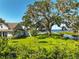 Expansive backyard featuring a huge tree, a storage shed and a dock on the water at 6200 Alligator Lake E Shr, St Cloud, FL 34771