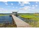 Scenic shot of a private dock with a covered boat lift on a calm waterway with lush vegetation in the background at 6200 Alligator Lake E Shr, St Cloud, FL 34771