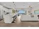 Bright, open kitchen with white cabinets, stainless appliances, and island seating, flowing to the living space at 6200 Alligator Lake E Shr, St Cloud, FL 34771