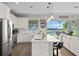 Modern white kitchen featuring stainless steel appliances, a farmhouse sink, and island with barstool seating at 6200 Alligator Lake E Shr, St Cloud, FL 34771