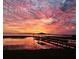 Vivid sunset reflecting off a tranquil lake, enhancing the beauty of the pier and nearby landscape at 6200 Alligator Lake E Shr, St Cloud, FL 34771
