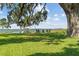 Expansive waterfront property with a dock and boat lift, seen from a lush lawn with mature trees and a firepit area at 6200 Alligator Lake E Shr, St Cloud, FL 34771