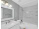 Bathroom with white marble tiled tub and shower surround, and single sink vanity at 6593 Meritmoor Cir, Orlando, FL 32818
