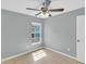 Bedroom features tile flooring, ceiling fan, and a window bringing in natural light at 6593 Meritmoor Cir, Orlando, FL 32818
