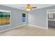 Bright bedroom features tile flooring, a ceiling fan, large windows, and a bathroom at 6593 Meritmoor Cir, Orlando, FL 32818