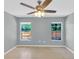 Bright bedroom features tile flooring, a ceiling fan, and two large windows at 6593 Meritmoor Cir, Orlando, FL 32818