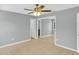 Bright bedroom features tile flooring, a ceiling fan, mirror closet doors, and a door to another room at 6593 Meritmoor Cir, Orlando, FL 32818