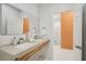 Elegant bathroom with double vanity, modern fixtures, and an open doorway leading to another room at 6632 Pasturelands Pl, Winter Garden, FL 34787