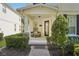 Inviting covered front porch with seating, decorative shrubbery, and brick walkway create a warm welcome at 6632 Pasturelands Pl, Winter Garden, FL 34787
