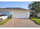 Attached two-car garage with brick paver driveway and manicured lawn at 6632 Pasturelands Pl, Winter Garden, FL 34787