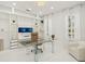 Bright office with built-in shelving, modern glass desk, and ample natural light at 6632 Pasturelands Pl, Winter Garden, FL 34787