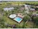 Aerial view of community pool, splashpad, and playground surrounded by lush landscaping and a serene lake at 6714 Bouganvillea Crescent Dr, Orlando, FL 32809