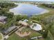 Stunning aerial view of the community pool, playground, and lake, surrounded by lush greenery and palm trees at 6714 Bouganvillea Crescent Dr, Orlando, FL 32809