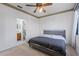 Modern bedroom featuring a sleek bed frame, ceiling fan, carpet, and ensuite bathroom access at 6714 Bouganvillea Crescent Dr, Orlando, FL 32809
