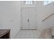 Bright foyer showcasing double doors, tiled floors, and a staircase leading upstairs at 6714 Bouganvillea Crescent Dr, Orlando, FL 32809