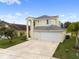 Charming two-story home featuring a three-car garage, lush lawn and palm trees at 6714 Bouganvillea Crescent Dr, Orlando, FL 32809